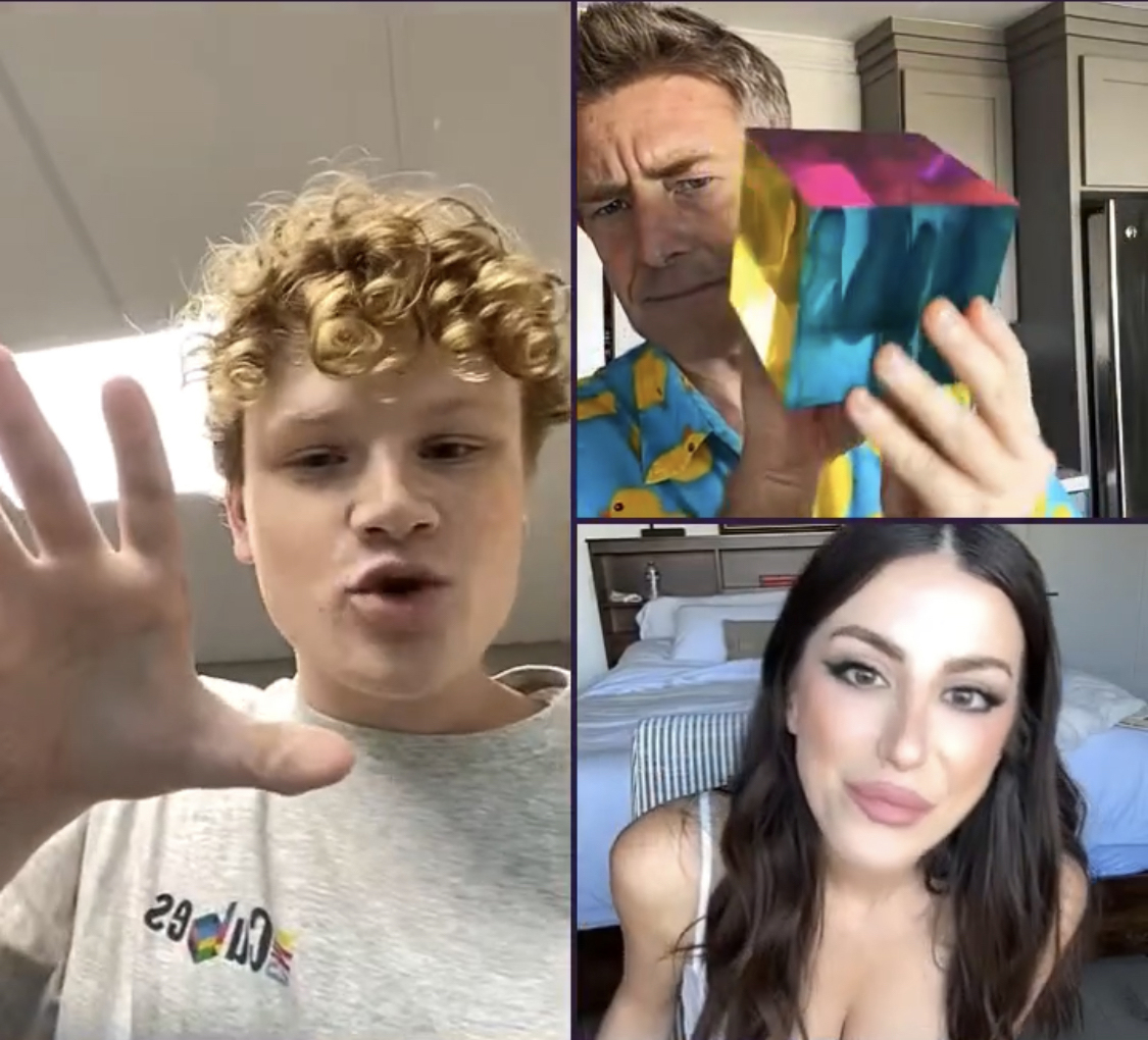 655cf8bd54a7aa6442fc6081_IMG_7941 A video call with three people: a curly-haired person, a man holding a colorful cube, and a woman in a bedroom.